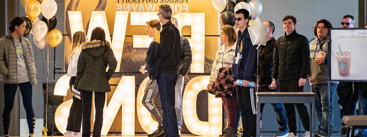 Visitors in front of the light up PFW DONS letters.